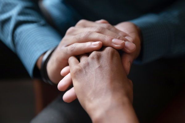A photo of hands being held in a comforting way