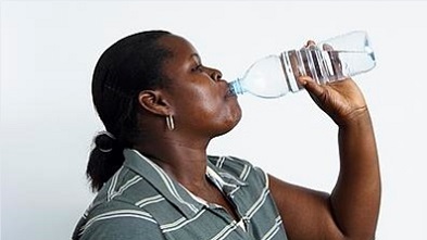 A woman drinking from a bottle of water
