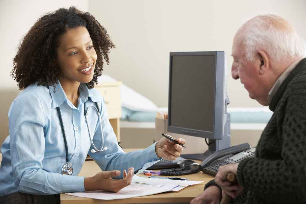 Young female doctor consulting with senior male patient
