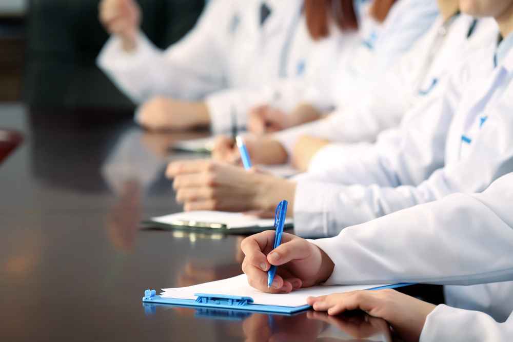 Medical workers in a conference room making notes