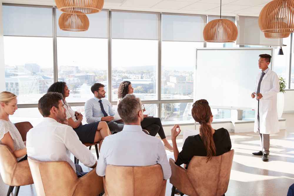 Young doctor making presentation to medical staff in conference room